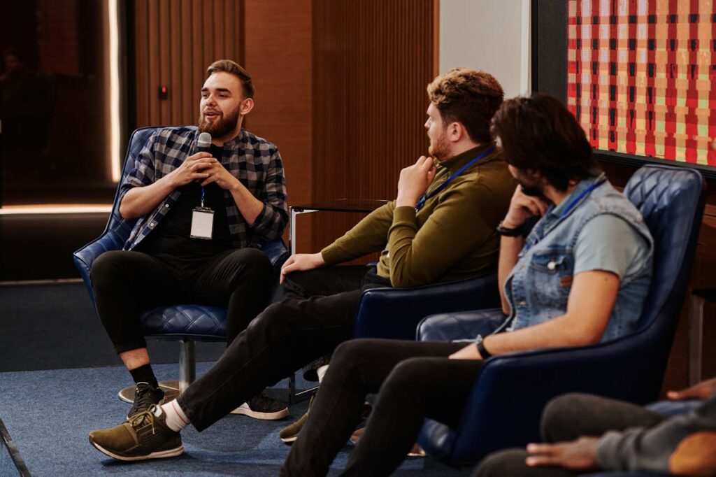 Group of young adults engaging in a lively panel discussion, fostering collaboration.